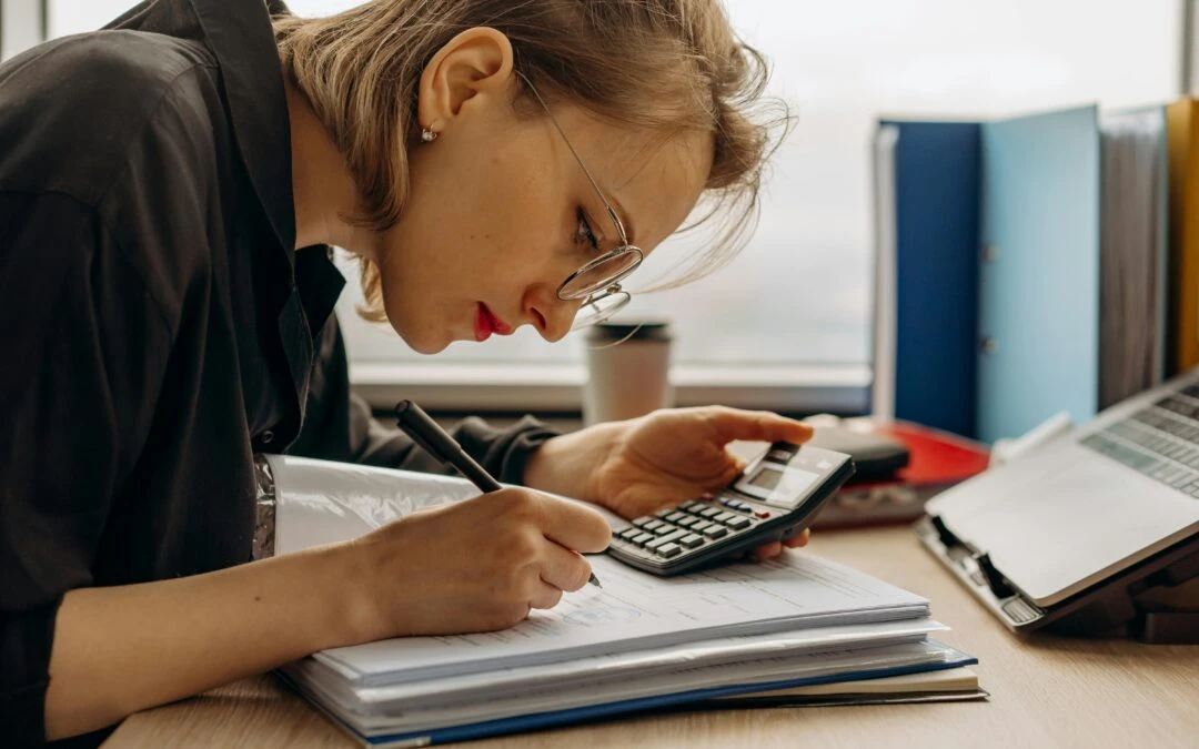 Small business owner reviewing disorganized accounting records on a laptop